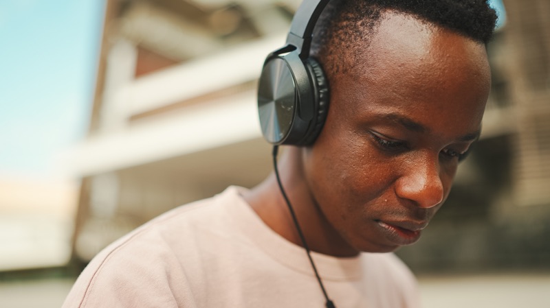 Young student listening outdoors